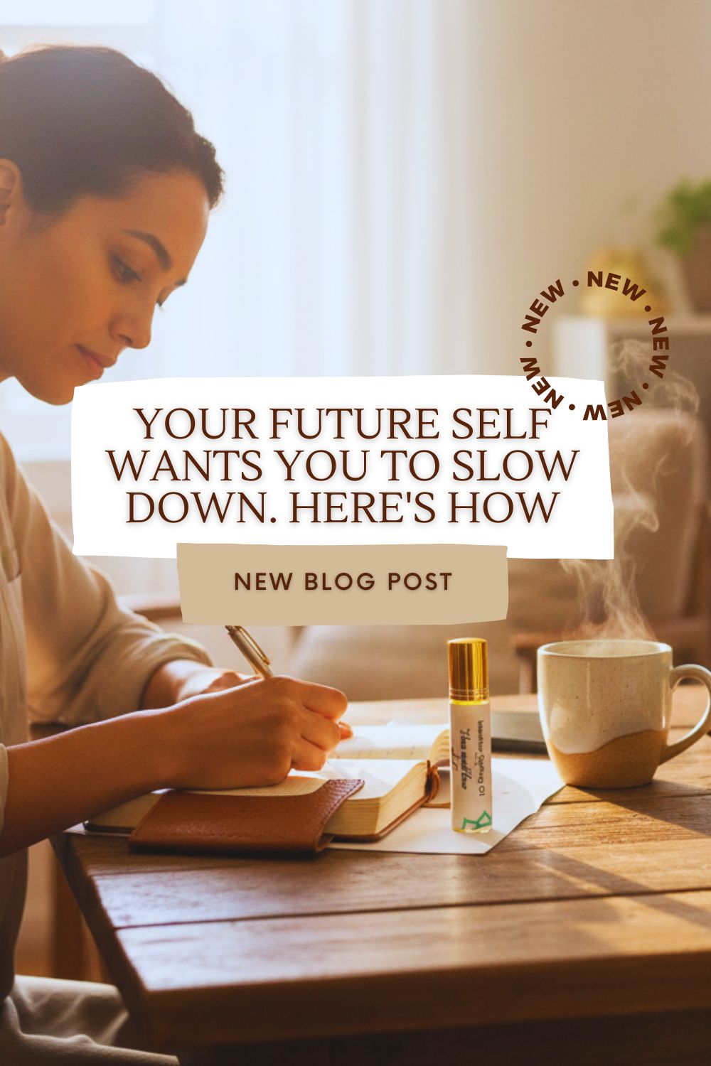 A woman writing in a journal. Next to the journal is an intention setting oil labeled "I love myself flaws and all" and a mug of hot tea