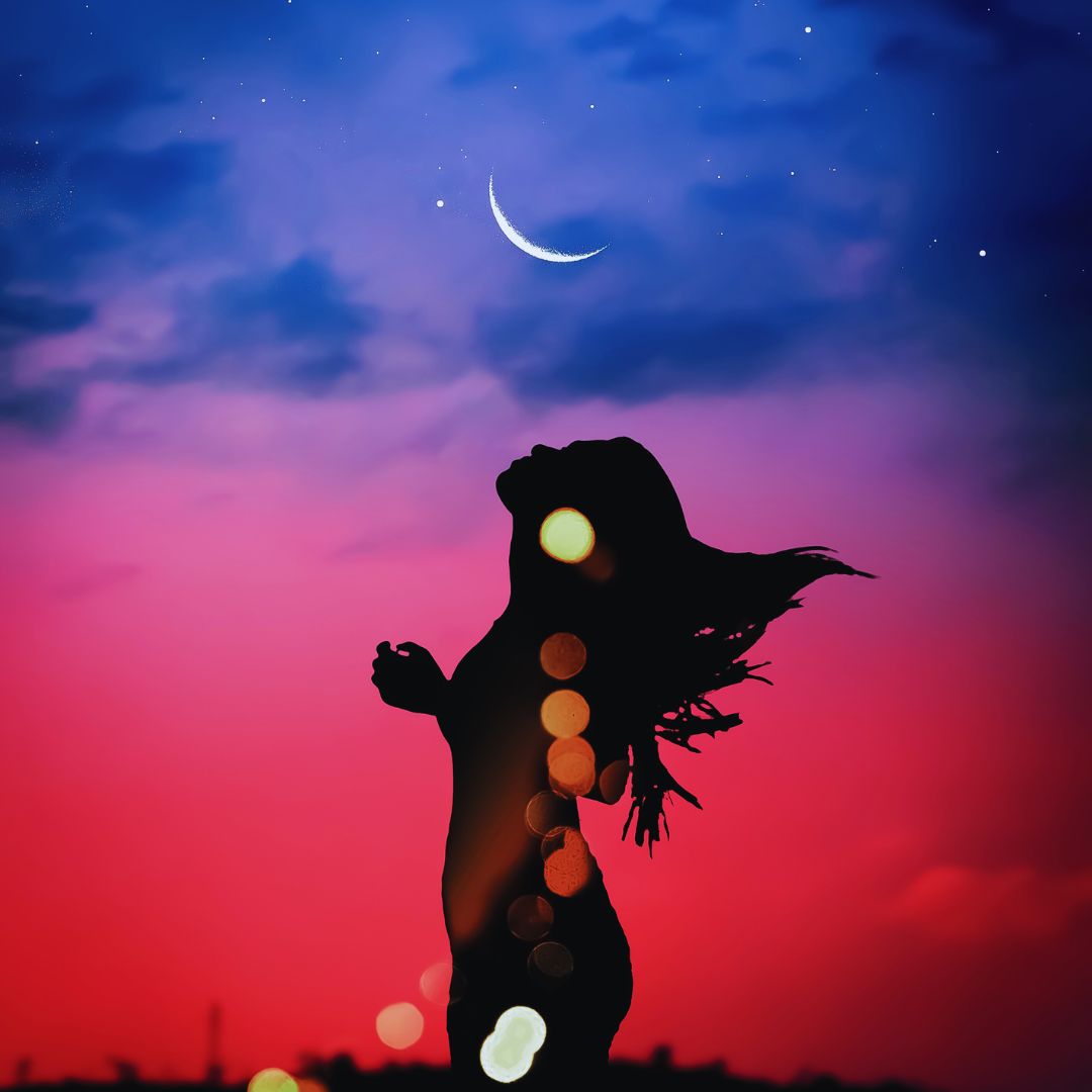 Silhouette of a woman dancing under a crescent moon for a 1-on-1 Lunar Reading and energy shift experience.